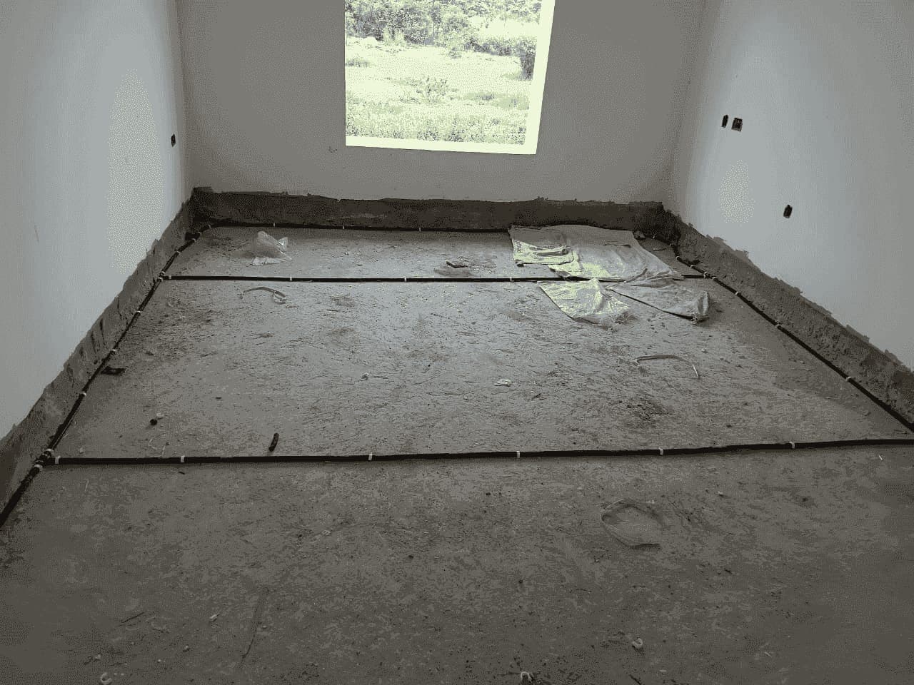 Anti-termite pipes fixed around all four walls of a room before the flooring is laid